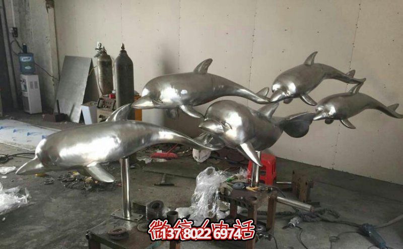 街边一群游玩的不锈钢海豚雕塑